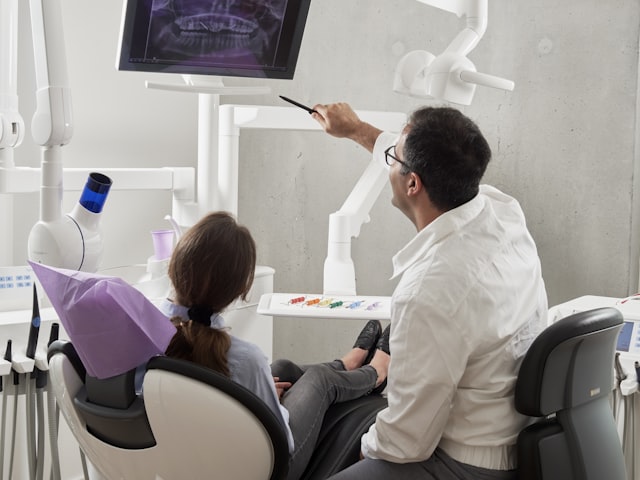 Dentista analisando uma tomografia de implante dentário em 3D em um monitor